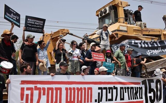 Des militants de La Paix Maintenant brandissant des pancartes : "150 avant-postes à démanteler. Homesh d'abord !", avant la manifestation prévue à l'avant-poste illégal de Homesh en Cisjordanie, le 28 mai 2022. (Crédit: La Paix Maintenant)