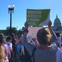 Des manifestante brandissent des pancartes au Rassemblement juif pour la Justice devant l'avortement, le mardi 17 mai 2022. (Crédit : A Julia Gergely)