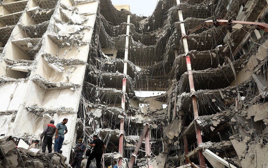 Des Iraniens rassemblés sur le site où un immeuble de dix étages s'est écroulé dans la ville d'Abadan, au sud-ouest de l'Iran, le 24 mai 2022. (Crédit : TASNIM NEWS / AFP)