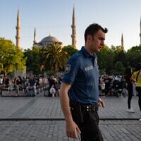 Un officier de police turc marchant devant la Mosquée bleue à Istanbul, le 14 juin 2022. (Crédit : Yasin Akgul/AFP)