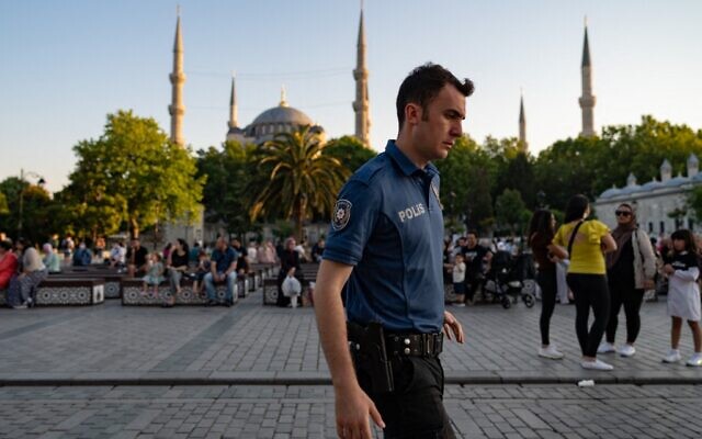 Un agent de la police anti-émeute turque marchant devant la Mosquée bleue à Istanbul, le 14 juin 2022. (Crédit: Yasin Akgul/AFP)