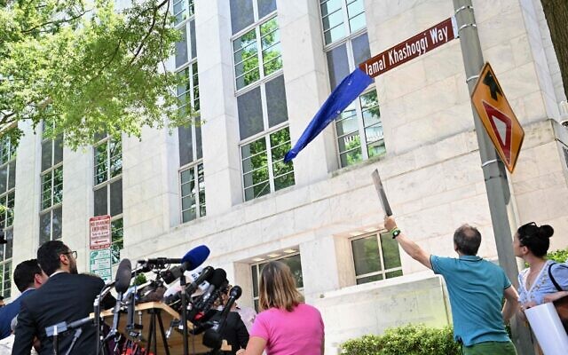 Des militants des droits de l'homme révèlent la nouvelle plaque de rue de Jamal Khashoggi Way lors d'un événement célébrant le changement de nom de la rue devant l'ambassade du Royaume d'Arabie saoudite, le 15 juin 2022 à Washington, DC. (Crédit : Nathan Howard/Getty Images/AFP)