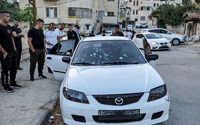 Des habitants inspectent le véhicule criblé de balles où trois Palestiniens armés ont été tués par des soldats israéliens dans la ville de Jénine, en Cisjordanie, le 17 juin 2022. (Crédit: Photo Jaafar ASHTIYEH / AFP)