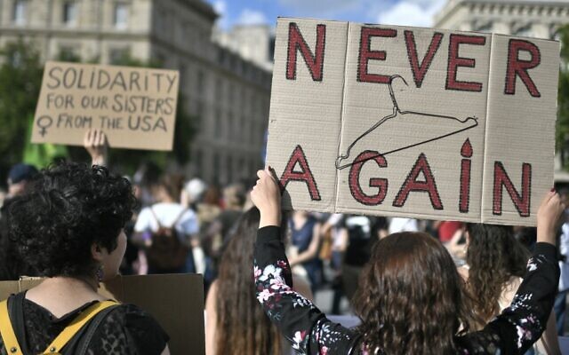 Des manifestants brandissent des panneaux en soutien au droit de l'avortement à Paris, après le renversement de l'arrêt américain qui gravait le droit à l'IVG dans la constitution, le 24 juin 2022. (Crédit : STEPHANE DE SAKUTIN / AFP)