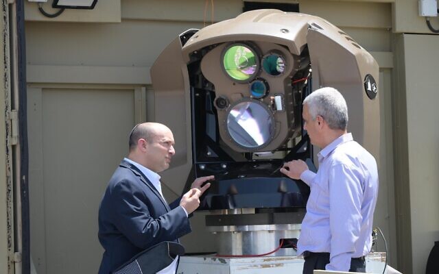Le Premier ministre Naftali Bennett (à gauche) découvre le nouveau système de défense aérienne au laser dans une usine d'armement de Rafael en Israël, le 31 mai 2022. (Crédit : Amos Ben Gershom/GPO)