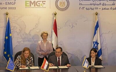 La présidente de la Commission européenne, Ursula von der Leyen (à l'arrière), regarde le commissaire européen à l'Énergie, Kadri Simson (à gauche), le ministre égyptien du Pétrole, Tarek el-Molla (à droite), et le ministre israélien de l'Énergie, Karine Elharrar (à droite), signer un accord trilatéral sur le gaz naturel lors de la réunion ministérielle du Forum du gaz de la Méditerranée orientale (FGME) au Caire, le 15 juin 2022. L'accord prévoit l'exportation de gaz naturel israélien, via l'Égypte, vers l'Europe. (Crédit : Khaled DESOUKI/AFP)