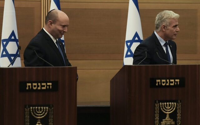 Le Premier ministre israélien Naftali Bennett, à gauche, et le ministre des Affaires étrangères Yair Lapid, quittent leur podium après une déclaration commune à la Knesset, annonçant l'effondrement de leur coalition, lundi 20 juin 2022. (Crédit : Maya Alleruzzo/AP)