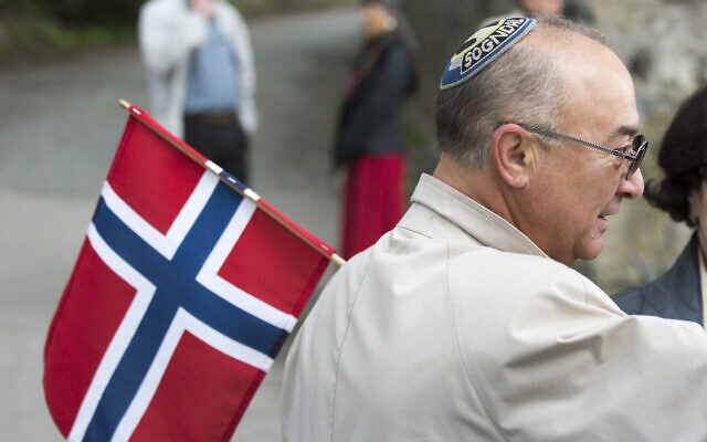 Un homme juif portant une kippa tient un drapeau norvégien le jour de la Constitution à Oslo. (Crédit : Fishman/ullstein bild/Getty Images/JTA)