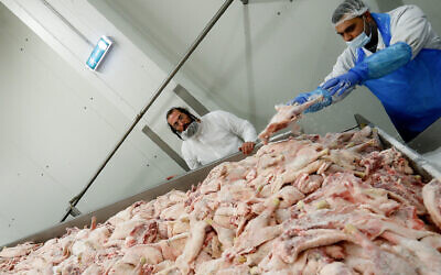 Photo d'illustration : Un rabbin orthodoxe contrôle la qualité de la viande de volailles dans un abattoir casher de Csengele, en Hongrie, le 15 janvier 2021. (Crédit : AP Photo/Laszlo Balogh)