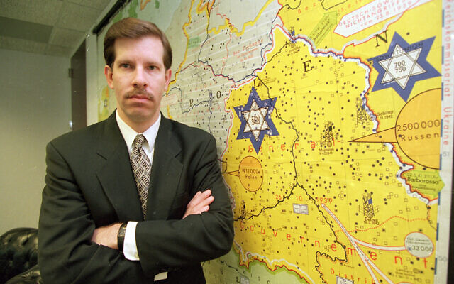 Eli Rosenbaum, ancien chef du Breau des enquêtes spéciales au ministère de la Justice, pose à côté d'une carte de l'Allemagne pendant la Seconde guerre mondiale qui montre les lieux des camps de concentration à Washington, le 29 mars 1995. (Crédit : AP Photo)