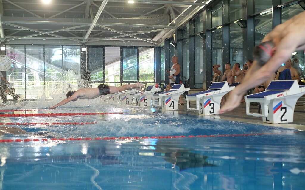 Des nageurs plongeant dans une piscine lors d'une rencontre dans le cadre des Jeux des anciens combattants britannico-israéliens à Tel Aviv, le 30 mai 2022. (Crédit: Judah Ari Gross/Times of Israel)