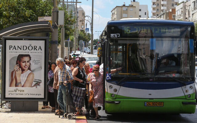Des Israéliens montent dans un bus Kavim dans la rue principale de la ville centrale de Petah Tikva, le 24 juin 2015. (Crédit: Nati Shohat/FLASH90)