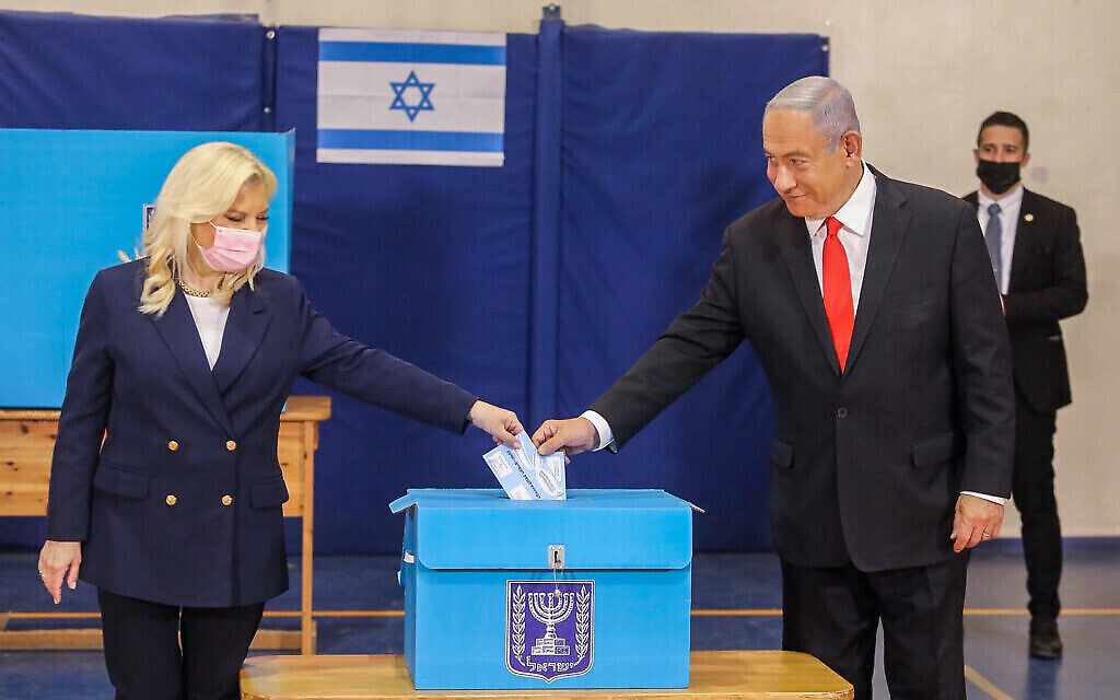 Le Premier ministre de l’époque, Benjamin Netanyahu, et son épouse Sara, votent dans un bureau de vote de Jérusalem, lors des élections à la Knesset le 23 mars 2021. (Crédit : Marc Israel Sellem/Pool)