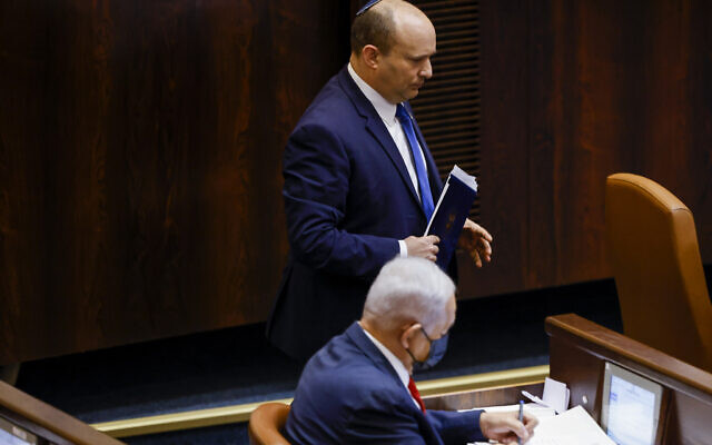 Le Premier ministre Naftali Bennett marche à côté du leader de l'opposition Benjamin Netanyahu dans la salle de l'assemblée pour une session spéciale en mémoire du premier Premier ministre israélien David Ben Gurion, le 8 novembre 2021. (Crédit: Olivier Fitoussi/Flash90)