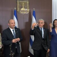 Le Premier ministre sortant Naftali Bennett,à gauche, et son remplaçant, le nouveau Premier ministre Yair Lapid, ainsi que leurs épouses, lors d'une cérémonie de passation de pouvoirs au bureau du Premier ministre à Jérusalem. (Crédit: Haim Zach/GPO)