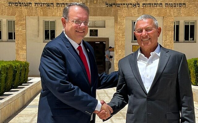 Le président par intérim de l'Agence juive pour Israël, Yaakov Hagoel, à gauche, serre la main du candidat au poste, Doron Almog, devant le siège de l'organisation à Jérusalem, le 16 juin 2022. (Crédit : Agence juive)