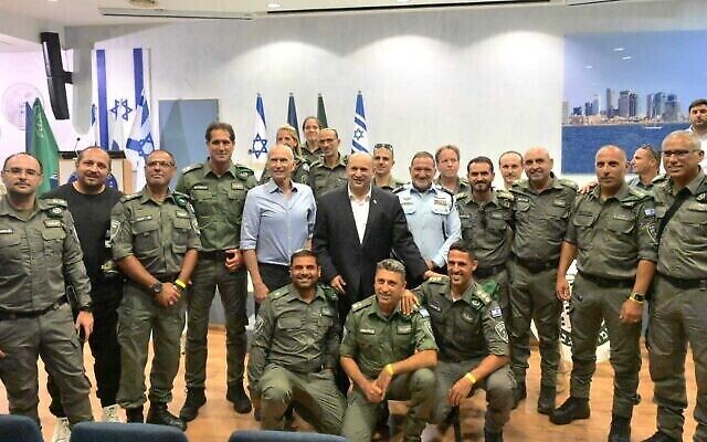 Le Premier ministre Naftali Bennett (au centre), le commissaire de police Kobi Shabtai (à droite), le ministre de la Sécurité publique Omer Barlev (à gauche) aux côtés des agents de la police des frontières dans un poste de police israélien, le 21 juin 2022. (Crédit : Amos Ben Gershom/GPO)