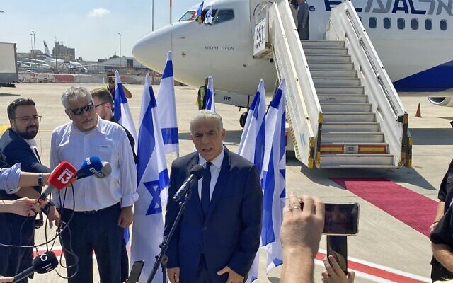 Le Premier ministre israélien Yair Lapid s'adresse à la presse avant d'embarquer sur son vol pour la France, à l'aéroport Ben Gourion de Lod, le 5 juillet 2022. (Crédit : Guillaume LAVALLÉE / AFP)