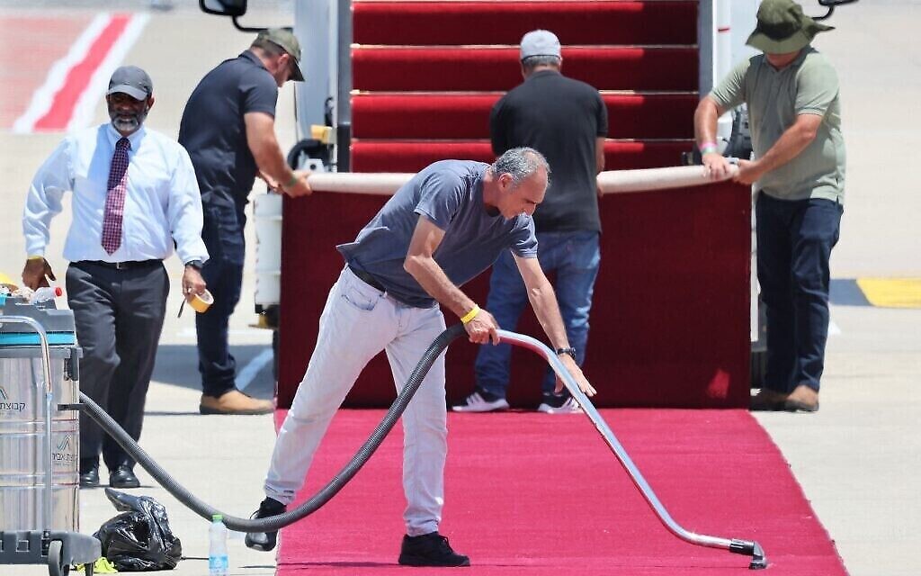 Des fonctionnaires nettoient le tapis rouge à l'aéroport israélien Ben Gourion de Lod, près de Tel Aviv, le 13 juillet 2022, avant l'arrivée du président américain Joe Biden pour une visite officielle. (Crédit : JACK GUEZ / AFP)
