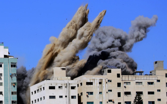 De la fumée s'élève de la tour Al-Jalaa dans la ville de Gaza, qui abritait des appartements et plusieurs agences de presse, dont l'Associated Press et Al Jazeera, après une frappe aérienne israélienne, le 15 mai 2021. (Atia Mohammed/Flash90)