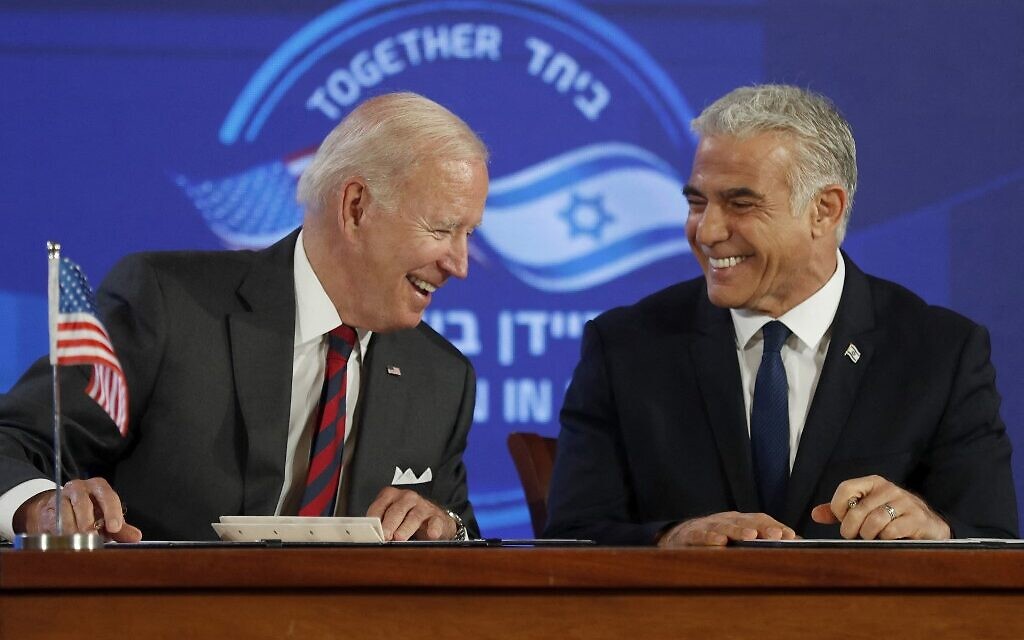 Le président américain Joe Biden, à gauche, et le Premier ministre intérimaire israélien Yair Lapid souriant après avoir signé un engagement de sécurité à Jérusalem, le 14 juillet 2022. (Crédit : Atef Safadi/AFP)