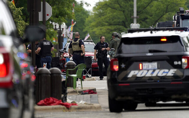 Les forces de l'ordre américaines effectuent des recherches dans le centre-ville de Highland Park, dans la banlieue de Chicago, après une fusillade lors du défilé du 4 juillet à Highland Park, le 4 juillet 2022. (AP Photo/Nam Y. Huh)