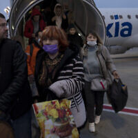 Des Ukrainiens débarquent d’un vol spécial affrété depuis la Roumanie, à l’aéroport Ben Gurion, le 8 mars 2022 (Crédit : AP Photo/Maya Alleruzzo)