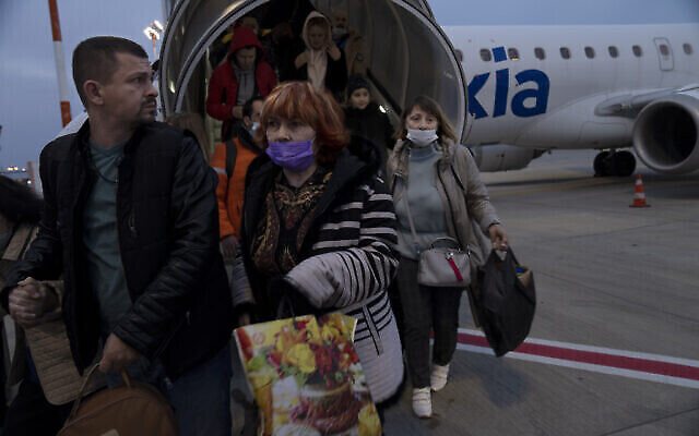 Des Ukrainiens débarquent d’un vol spécial affrété depuis la Roumanie, à l’aéroport Ben Gurion, le 8 mars 2022 (Crédit : AP Photo/Maya Alleruzzo)