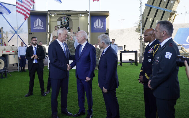 Le président américain Joe Biden parle au ministre de la Défense Benny Gantz et au Premier ministre Yair Lapid à une exposition des systèmes de défenses israéliens, le 13 juillet 2022. (Crédit : AP Photo/Evan Vucci)