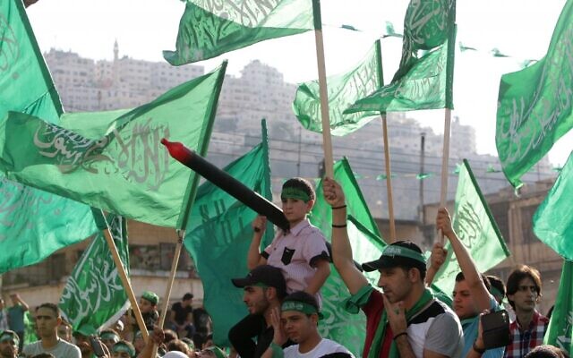 Photo d'illustration : Des Palestiniens avec des drapeaux du Hamas pendant une célébration organisée par le groupe terroriste à Naplouse, en Cisjordanie, le 29 août 2014. (Crédit : AP/Nasser Ishtayeh)
