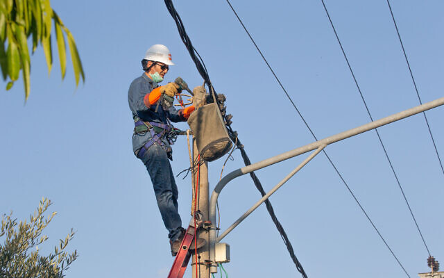 Un ouvrier de la Compagnie israélienne d'électricité répare une ligne défectueuse, le 29 août 2020. (Crédit : Yossi Aloni/FLASH90)