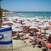 Les Israéliens profitant de la plage de Tel Aviv par une chaude journée, le 9 juillet 2022. (Crédit : Avshalom Sassoni/Flash90)