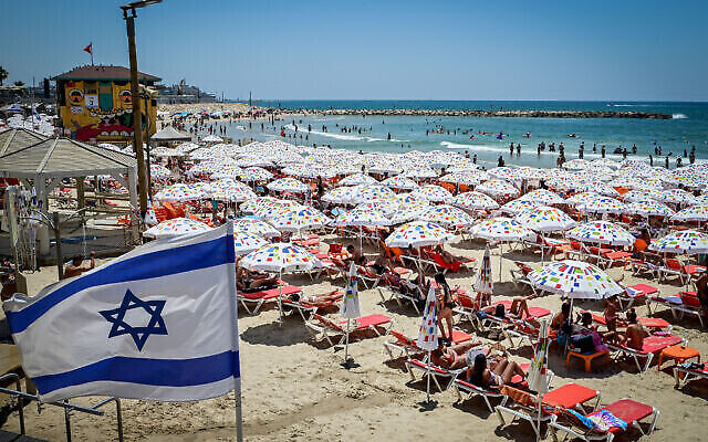 Les Israéliens profitent de la plage de Tel Aviv par une chaude journée, le 9 juillet 2022. (Crédit : Avshalom Sassoni/Flash90)