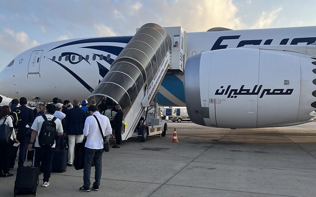 Le service de presse de la Maison Blanche se prépare à embarquer à bord d'un avion d'Egypt Air à destination de Jeddah, à l'aéroport Ben Gurion de Tel Aviv, le 15 juillet 2022. (Crédit :  Jacob Magid/Times of Israel)