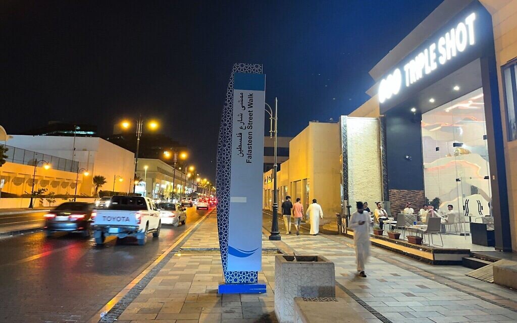 Le panneau signalant la rue de la Palestine avec la fontaine du roi Fahd en arrière-plan à Jeddah, en Arabie saoudite, le 16 juillet 2022. (Crédit :  Jacob Magid/Times of Israel)