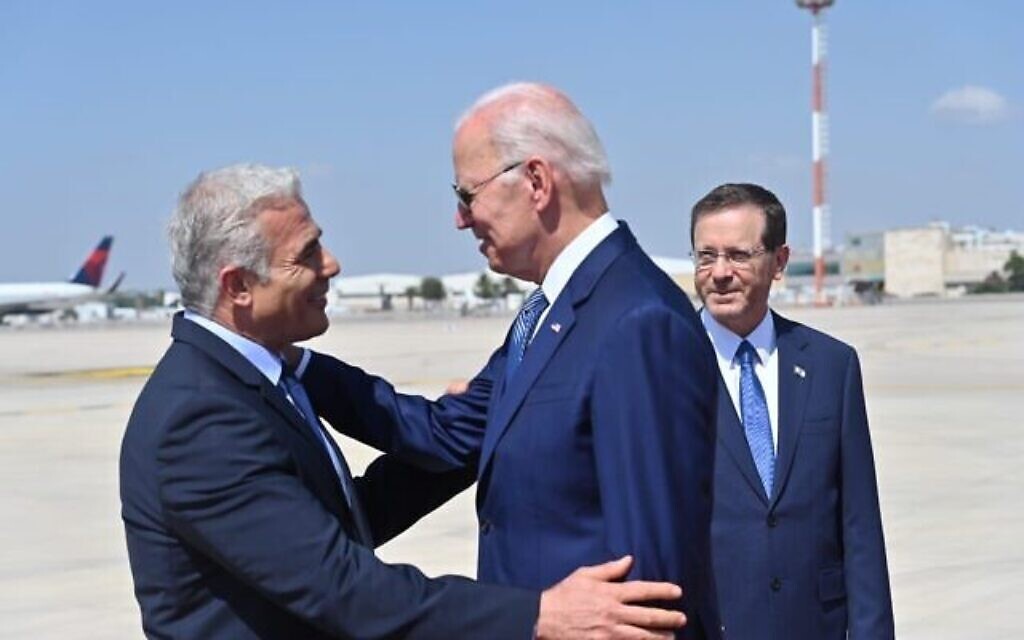 Le Premier ministre Yair Lapid salue le président américain Joe Biden à l'aéroport Ben Gurion, le 13 juillet 2022. (Crédit : Kobi Gideon/GPO)
