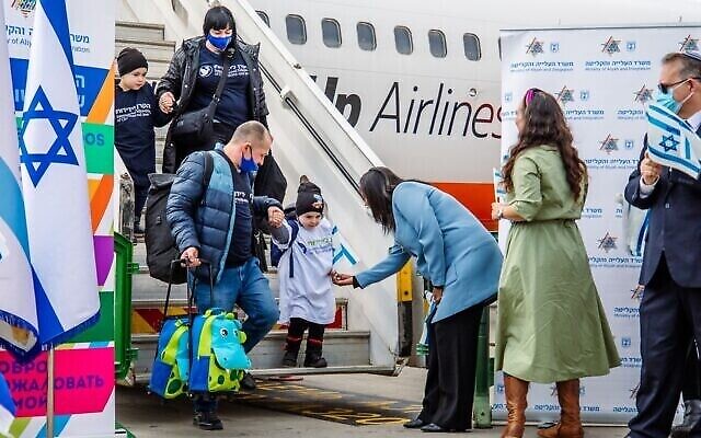 La ministre Pnina Tamano-Shata, au centre, en manteau bleu, accueille de nouveaux immigrants originaires d’Ukraine à l’aéroport Ben-Gurion en Israël, dans des photos non datées distribuées par le ministère de l’Immigration et de l’Absorption le 6 juillet 2022. (Crédit : Avec la permission de Naga Malasa)