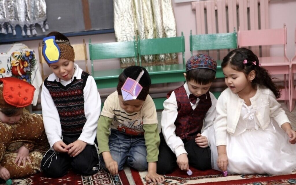 Sur cette photographie non datée, de jeunes enfants jouent avec des dreidels pour célébrer la fête de Hanoukka dans un jardin d’enfants juif géré par Chabad à Bichkek, Kirghizistan. (Crédit : Fédération des communautés juives de la CEI)
