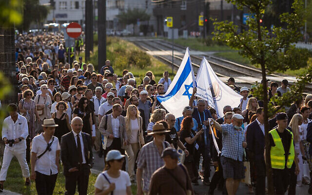 Des gens assistent à une marche du souvenir lors des cérémonies du 22 juillet 2022 marquant le 80e anniversaire du début de la déportation massive par l'Allemagne nazie des Juifs du ghetto de Varsovie vers le camp de la mort de Treblinka. (Crédit : Wojtek Radwanski/AFP)