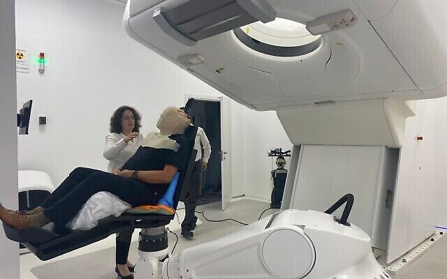 Nouvelle installation de protonthérapie à l'hôpital Hadassah de Jérusalem : un patient dans une chaise porte un masque en plastique couvrant son visage, pour le protéger des radiations (Crédit : Courtoisie de l'hôpital Hadassah)