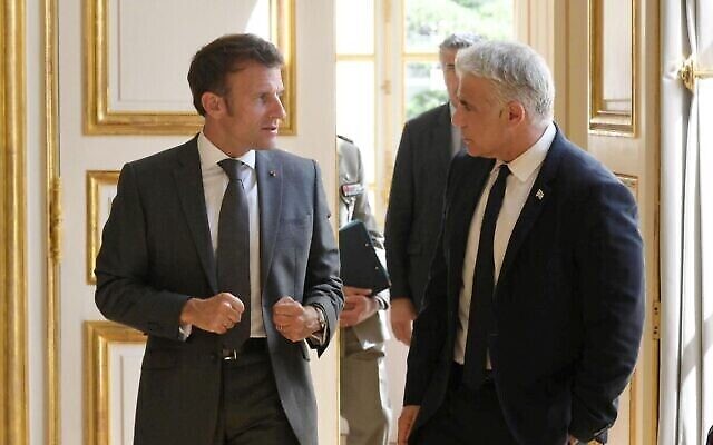 Le Président français Emmanuel Macron (à gauche) et le Premier ministre Yair Lapid s'entretiennent au Palais de l’Elysée à Paris, le 5 juillet 2022 (Crédit : Amos Ben Gershom/GPO)