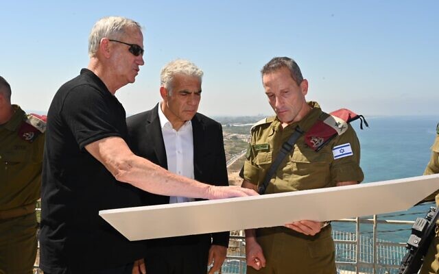 Le ministre de la Défense Benny Gantz, à droite, le Premier ministre Yair Lapid, au centre, et le chef du Commandement Nord Amir Baram à la frontière libanaise, près de la côte, le 19 juillet 2022. (Crédit : Amos Ben Gershom/GPO)