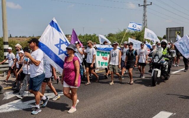 Des manifestants marchant lors d'un rassemblement à l’initiative  des membres de la famille Goldin, de la ville israélienne d'Ashkelon vers le kibboutz Karmia, le 5 août 2022. (Crédit : Jack Guez/AFP)