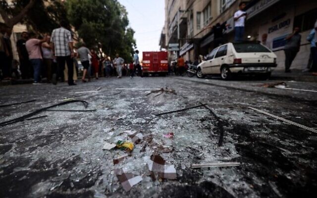 Du verre brisé est éparpillé le long d'une rue après une frappe aérienne israélienne sur la ville de Gaza, le 5 août 2022. (Crédit : Mohammed ABED / AFP)