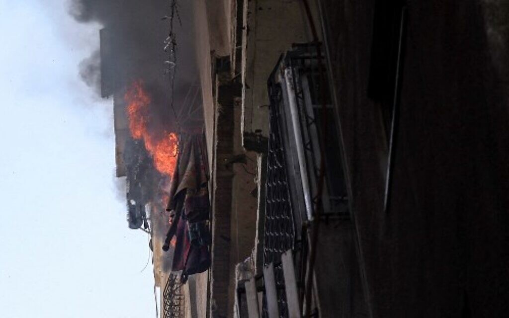 Des flammes s'élèvent d'un bâtiment après une frappe aérienne israélienne sur la ville de Gaza, le 5 août 2022. (Crédit : Mohammed ABED / AFP)
