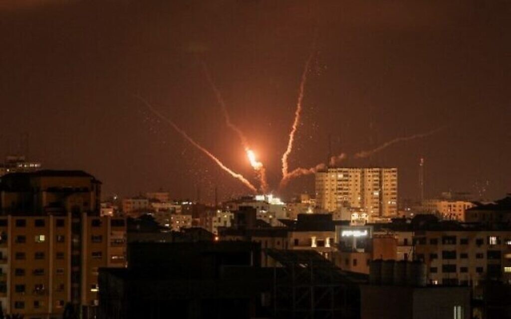 Des roquettes palestiniennes sont tirées depuis la ville de Gaza en représailles à de précédentes frappes aériennes israéliennes, le 5 août 2022. (Crédit : Mahmud Hams / AFP)