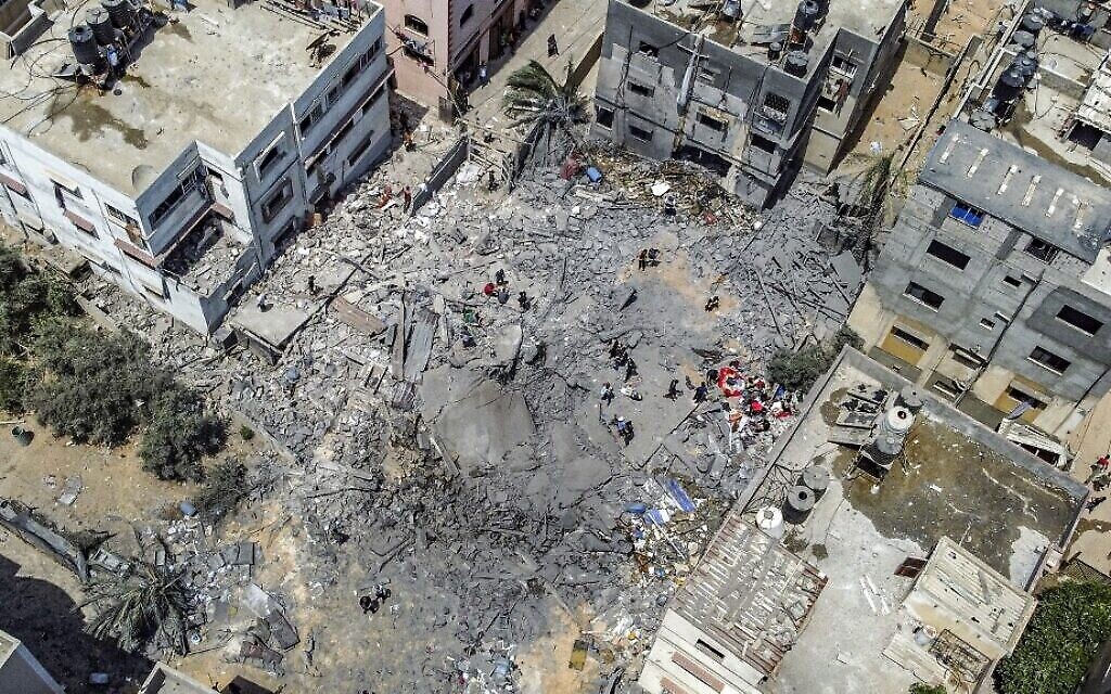 Cette vue aérienne montre des Palestiniens inspectant les ruines d'un bâtiment détruit par une frappe aérienne israélienne dans la ville de Gaza, le 6 août 2022. (Mohammed Abed/AFP)
