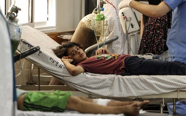 Un enfant palestinien blessé à la suite de frappes aériennes israéliennes reçoit des soins à l'hôpital al-Shifa, dans la ville de Gaza, le 6 août 2022. (Crédit : Mahmud HAMS / AFP)