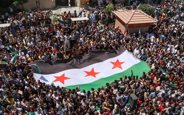 Des Syriens se rassemblent pour protester contre une proposition du ministre turc des Affaires étrangères de réconciliation entre le gouvernement syrien et l'opposition, dans la ville frontalière d'Azaz, dans le nord de la province d'Alep, tenue par les rebelles, le 12 août 2022. (Crédit : AFP)