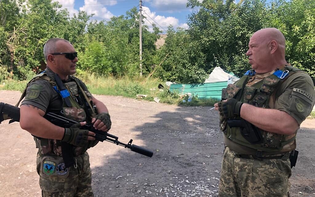 Oleksander (L) et Volodymyr, officiers du 128e bataillon de la Force de défense territoriale, discutent à Chuhuiv, le 28 juillet 2022. (Crédit : Lazar Berman/The Times of Israel)